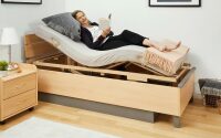 Lesen in Sitzposition mit einem Betteinsatz der Lippe-Serie im Seniorenbett Relax