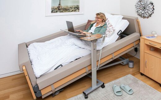 Pflegebett Regia gardo mit Beistelltisch Pleto und Laptop