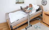 Pflegebett Regia gardo mit Beistelltisch Pleto und Laptop